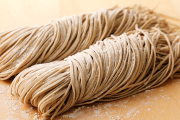 生そば　Raw soba noodles on wooden board background.