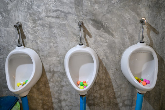 White urinals with colorful mothball in men toilet