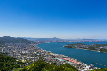 Fototapeta na wymiar 風頭から見た、五月晴れの関門海峡と北九州市街地と彦島