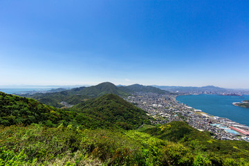 Naklejka premium 風頭から見た、関門海峡と北九州市街地と北九州を代表する山々（高塔山、皿倉山、福智山、足立山、貫山、戸の上山 遠く由布岳を望む）