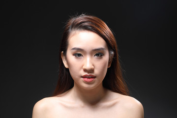 Young beautiful Asian woman makeup dark background 