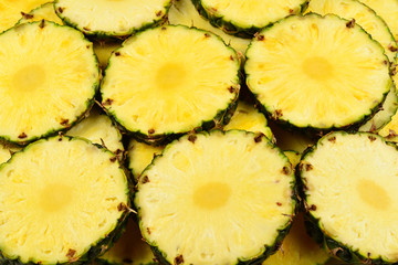 Pineapple juicy yellow slices background. Top view.