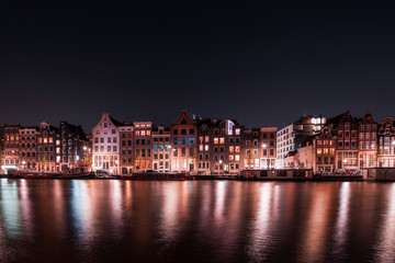 Fototapeta na wymiar Amsterdam City night river water reflection long expo landscape tourist vacation attraction houses, Holland, Netherlands