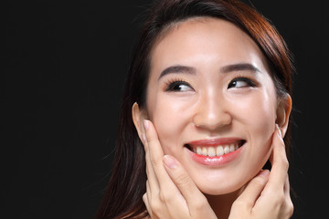 Young beautiful Asian woman makeup dark background 