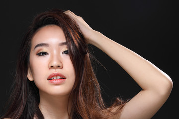 Fototapeta premium Young beautiful Asian woman makeup dark background 