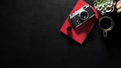 Header web concept, Dark leather desk with vintage camera, red notebook and copy space