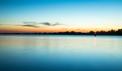 Fototapeta premium scenic blue sunset time on the river with smooth water