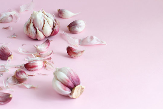 Fresh garlic on a light pink background