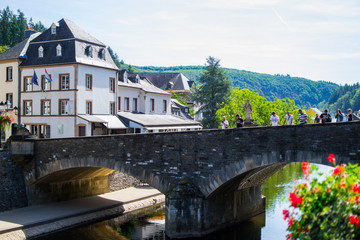 View of the Our river with a stone bridge in the old town of Vianden, Luxembourg, with typical houses at the background