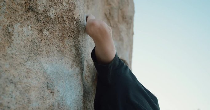 Close up of young man climbing outside 
