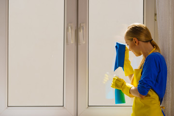 Woman cleaning window at home