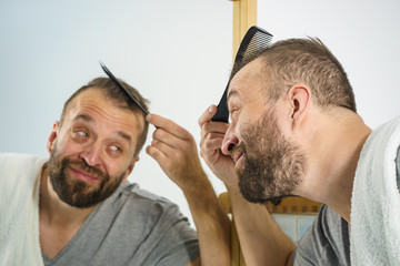 Obraz premium Man using comb in bathroom