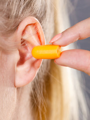 Woman putting earplugs