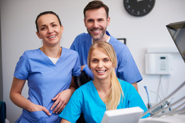 Team of happy stomatologists in dentist's clinic