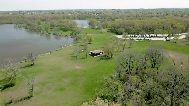 Aerial orbiting around a pavilion in a public park near a lake. Tampier Slough lake in the western suburbs of Chicago, Illnois, near Lemont.