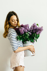 Girl with a bouquet of lilac on a white background