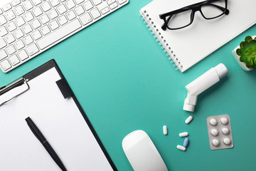 Stethoscope in doctors desk with notebook, pen, keyboard, mouse and pills