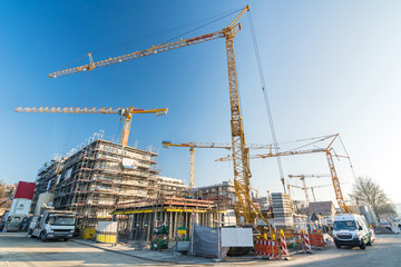 Weitwinkelaufnahme von Baustelle und Rohbau von Büros und Mehrfamilienhäusern mit vielen Kränen...