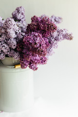 Purple bouquet of lilac flowers in a stylish vase on a white background