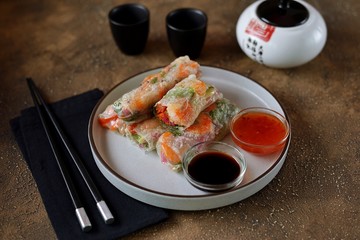 Rice spring rolls - rice paper, carrots, watermelon radish, tomato, cucumber, coriander and fried shrimp. Healthy food.