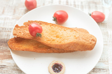 Bread, milk, eggs and fruit are on the table