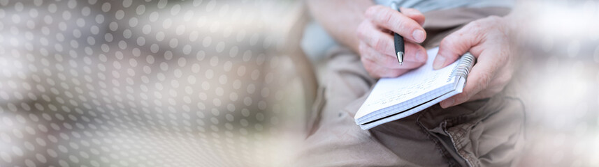 Man taking notes on a pocket book. panoramic banner
