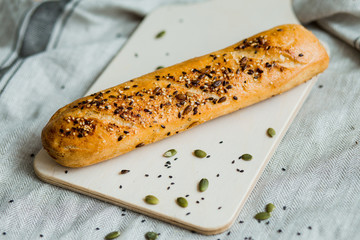Freshly baked bread on dark grey fabric with seed