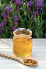 Jar of organic floral honey with a bee pollen. Outdoor. Vertical shoot