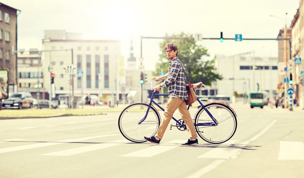 Fototapeta people, style, city life and lifestyle - young hipster man with shoulder bag and fixed gear bike crossing crosswalk on street