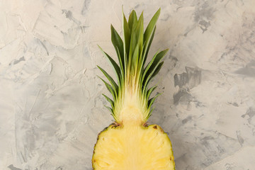 Large ripe fruit pineapple. Half a pineapple on a light concrete background. summer. top view