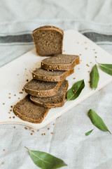 fresh sliced bread on a wooden board on a grey cloth