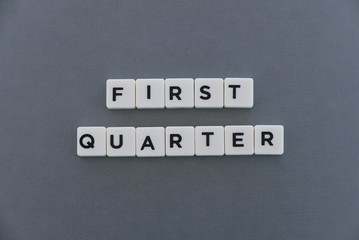 First quarter word made of square letter word on grey background.