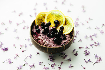 healthy smoothie bowl breakfast in a glass jar with lilac flowers