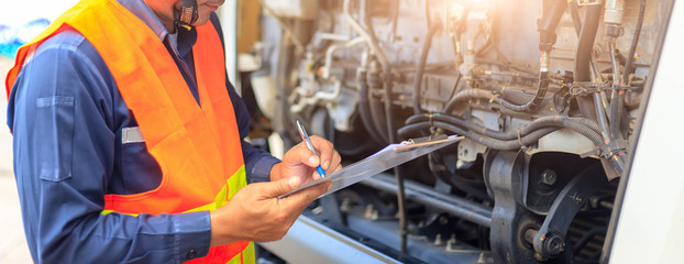 Preforming a pre-trip inspection on a truck,Concept preventive maintenance truck checklist,Check truck engine,Check the lubricating oil,spot focus. © KM.Photo