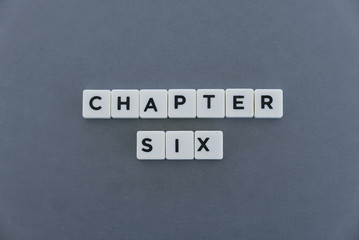 Chapter six word made of square letter word on grey background.