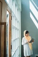 lifestyle of young muslim woman wearing hijab using tablet pc