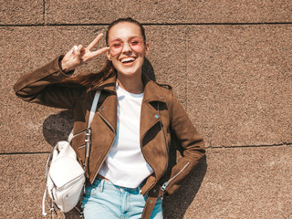 Portrait of beautiful smiling brunette model dressed in summer hipster jacket and jeans clothes....