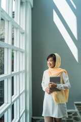Fototapeta premium lifestyle of young muslim woman wearing hijab using tablet pc