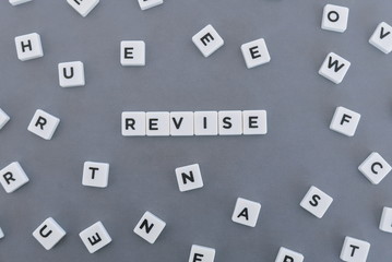 Revise word made of square letter word on grey background.