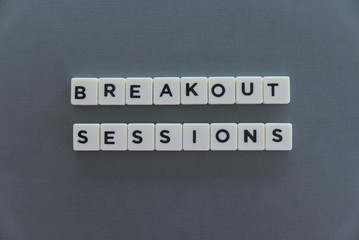 Breakout Sessions word made of square letter word on grey background.