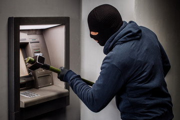Thief. Hacker stealing money from ATM machine. Phishing, ATM skimming