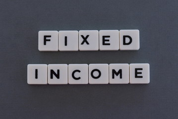 Fixed Income word made of square letter word on grey background.