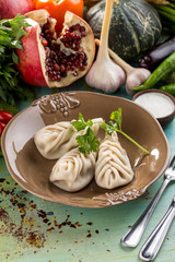 fresh boiled dumplings and fresh vegetables on blue wooden table