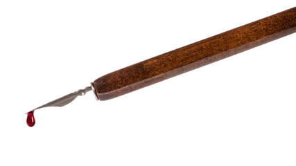 ink drop dripping from nib of brown dip pen