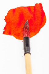 red colored tip of paintbrush in red blot close up