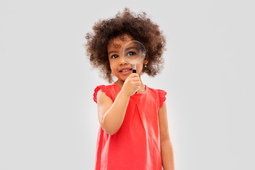 investigation, discovery and vision concept - happy little african american girl looking through...