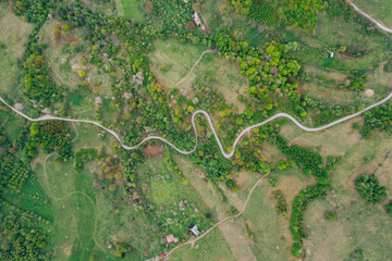 Drone view of green meadows, small houses and roads in Transylvania, Romania.