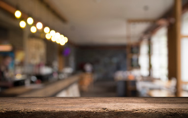 image of wooden table in front of abstract blurred background of resturant lights