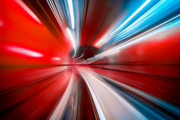 Sentier lumineux concentrique coloré abstrait accélérant à travers un tunnel.