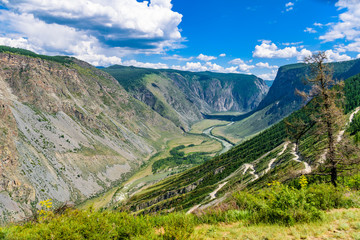 Awesome landscape of Altai Mountains with gorge, mountain road, mountain river, blue sky and beautiful clouds